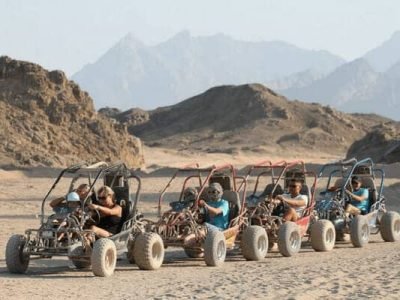 Poszukiwacze przygód jeżdżący quadami o zachodzie słońca na pustynnym szlaku podczas Sunset Quad Safari Trip Marsa Alam