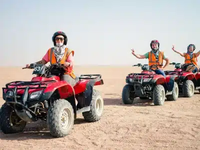 Poszukiwacze przygód jeżdżący quadami o zachodzie słońca na pustynnym szlaku podczas Sunset Quad Safari Trip Marsa Alam