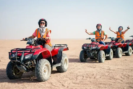 Poszukiwacze przygód jeżdżący quadami o zachodzie słońca na pustynnym szlaku podczas Sunset Quad Safari Trip Marsa Alam