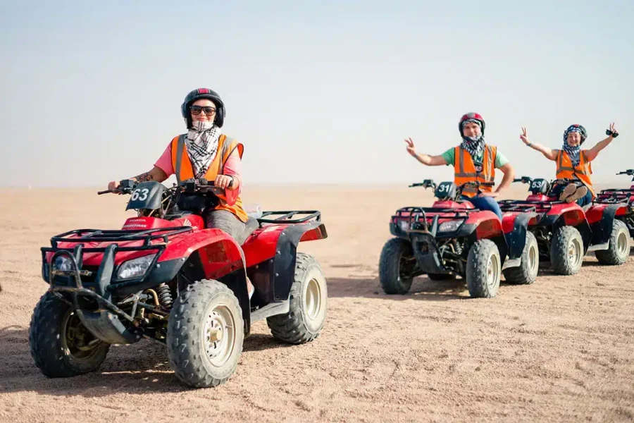 Poszukiwacze przygód jeżdżący quadami o zachodzie słońca na pustynnym szlaku podczas Sunset Quad Safari Trip Marsa Alam
