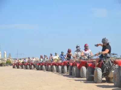 Poszukiwacze przygód jeżdżący quadami o zachodzie słońca na pustynnym szlaku podczas Sunset Quad Safari Trip Marsa Alam