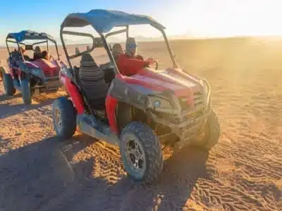 Pustynny rower buggy w Sharm El Sheikh ścigający się po wydmach pod zachodem słońca