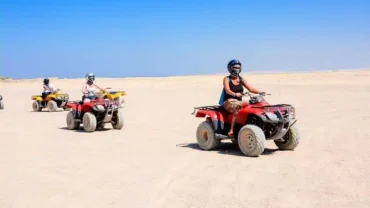 Private Family Safari in Egypt with a jeep driving through golden dunes at sunset