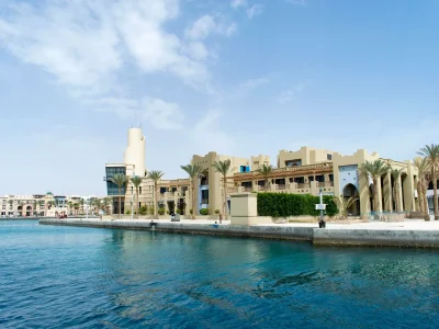 Port Ghalib shopping area with colorful boutiques, waterfront cafes, and tourists browsing souvenirs