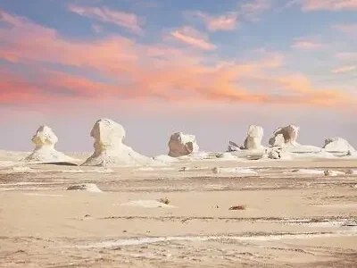 White Desert in Egypt with unique chalk rock formations under a blue sky