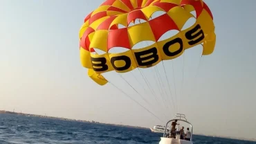 Parasailing over the turquoise Red Sea in Hurghada with a parachute attached to a speedboat