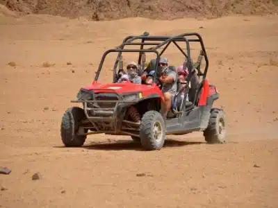 Buggy Bike Sharm El Sheikh racing across golden desert dunes with mountains in the background
