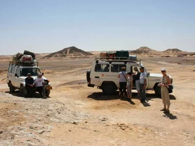 Super Safari Trip Marsa Alam with tourists riding quad bikes across golden desert dunes at sunset