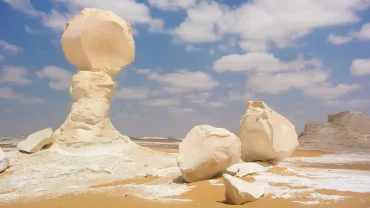 White Desert in Egypt with unique chalk rock formations under a blue sky