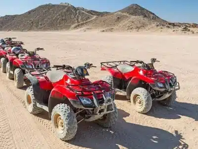 Buggy Bike Sharm El Sheikh racing across golden desert dunes with mountains in the background