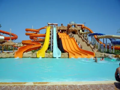 Colorful water slides and pools at Jungle Aqua Park in Hurghada with people enjoying a sunny day