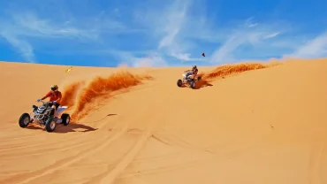 Desert Quad Bike in Sharm El Sheikh adventure racing through golden sand dunes under a sunny sky