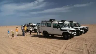 Family Jeep Safari in Egypt driving through desert dunes with mountains in the background