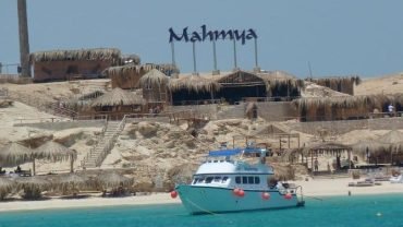 Tourists relaxing on Mahmya Island beach with turquoise Red Sea waters