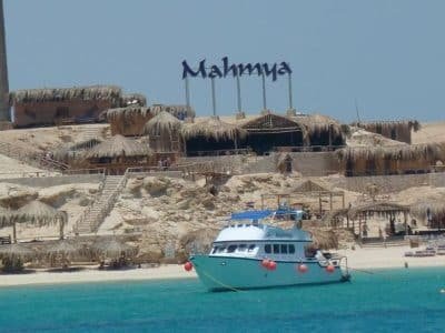 Tourists relaxing on Mahmya Island beach with turquoise Red Sea waters