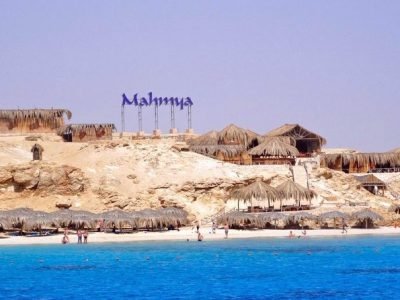Tourists relaxing on Mahmya Island beach with turquoise Red Sea waters