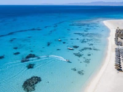 Tourists relaxing on Mahmya Island beach with turquoise Red Sea waters